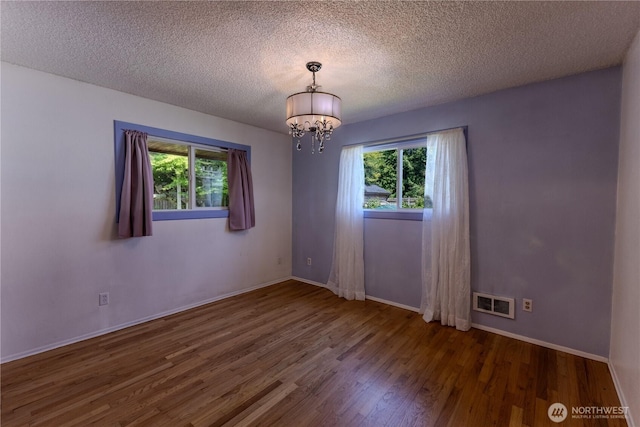 1035 Oakes Ave, Everett, WA 98201 - unfurnished room featuring wood finished floors, plenty of natural light, a chandelier, a textured ceiling, and baseboards