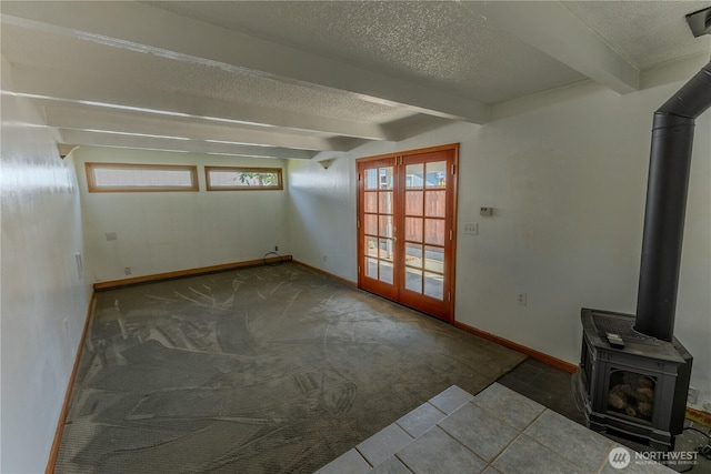 1035 Oakes Ave, Everett, WA 98201 - unfurnished living room featuring french doors, a wood stove, beam ceiling, carpet, and a textured ceiling