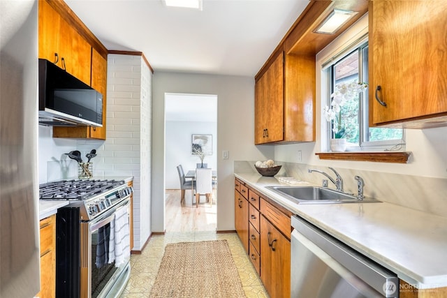 17618 Meridian Ave N, Shoreline, WA 98133 - kitchen featuring stainless steel appliances, a sink, light countertops, and brown cabinets
