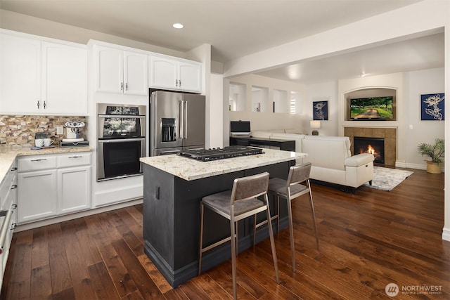 16148 Parkside Way SE, Renton, WA 98058 - kitchen with stainless steel appliances, recessed lighting, open floor plan, a tile fireplace, and a center island