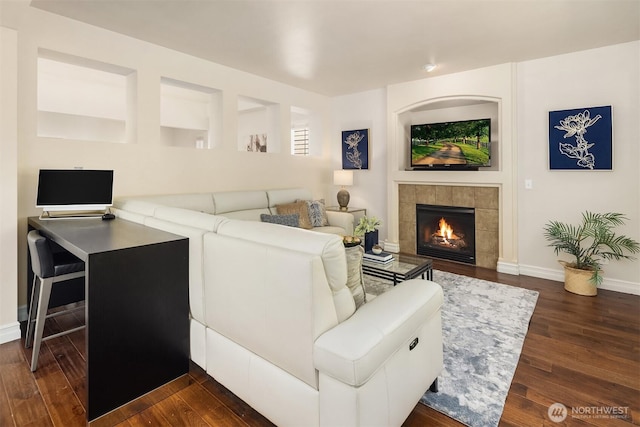 16148 Parkside Way SE, Renton, WA 98058 - living area with dark wood-style flooring, a tiled fireplace, and baseboards