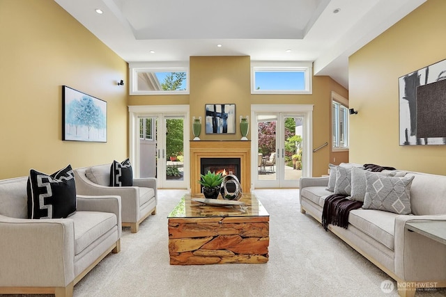 18737 63rd Ave NE, Kenmore, WA 98028 - carpeted living room with french doors, a high ceiling, recessed lighting, and a warm lit fireplace