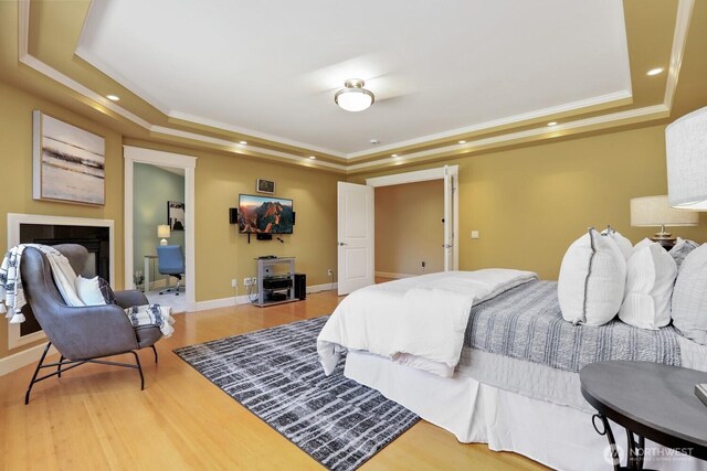 18737 63rd Ave NE, Kenmore, WA 98028 - bedroom featuring a tray ceiling, ornamental molding, wood finished floors, a fireplace, and recessed lighting