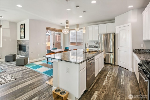 458 SW 111th Pl, Seattle, WA 98146 - kitchen featuring stainless steel appliances, a sink, dark wood-type flooring, dark stone counters, and recessed lighting