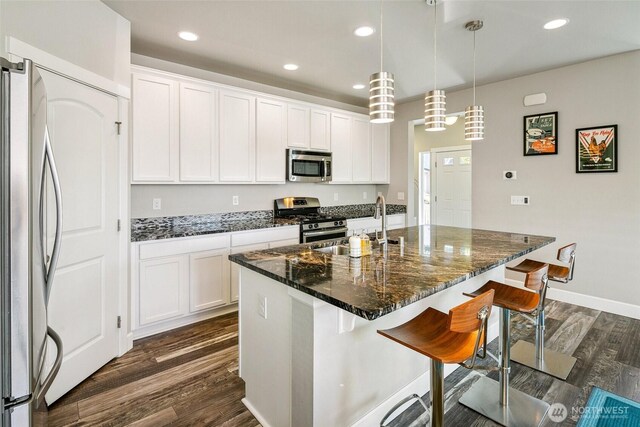 458 SW 111th Pl, Seattle, WA 98146 - kitchen with appliances with stainless steel finishes, dark wood finished floors, a breakfast bar, white cabinetry, and recessed lighting