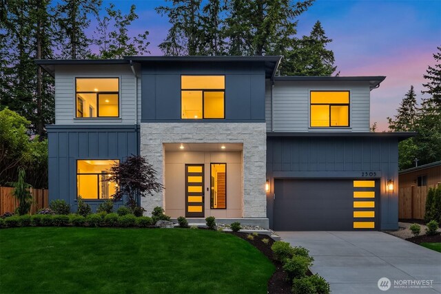 2505 166th Ave SE, Bellevue, WA 98008 - contemporary home featuring a garage, stone siding, concrete driveway, and board and batten siding