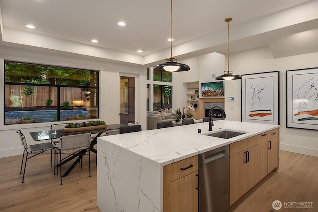 2505 166th Ave SE, Bellevue, WA 98008 - kitchen with a sink, open floor plan, light wood-style floors, light stone counters, and a kitchen island with sink