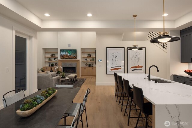 2505 166th Ave SE, Bellevue, WA 98008 - dining room featuring light wood finished floors, recessed lighting, a lit fireplace, baseboards, and built in features