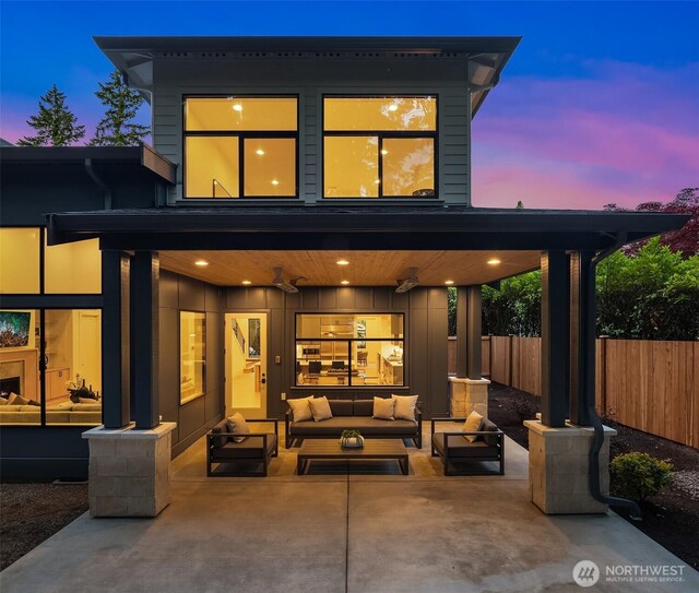 2505 166th Ave SE, Bellevue, WA 98008 - back of property at dusk with outdoor lounge area, a patio, and board and batten siding
