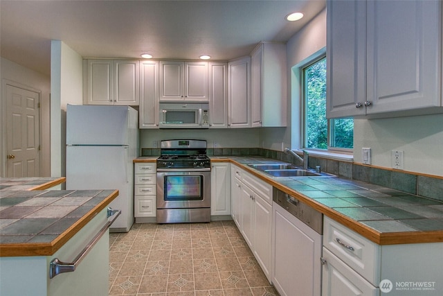 101 Tomihi Dr, Orcas Island, WA 98245 - kitchen with appliances with stainless steel finishes, a sink, tile counters, white cabinets, and recessed lighting