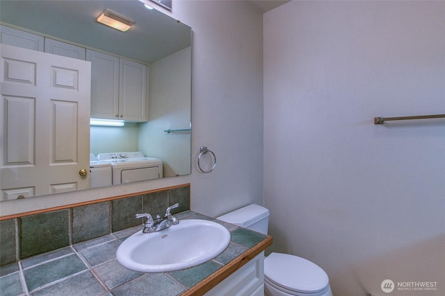 101 Tomihi Dr, Orcas Island, WA 98245 - half bath featuring washing machine and clothes dryer, toilet, vanity, and tasteful backsplash
