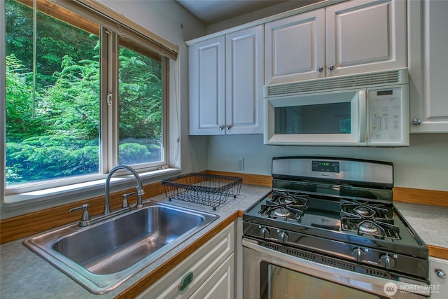 101 Tomihi Dr, Orcas Island, WA 98245 - kitchen featuring stainless steel gas stove, white microwave, a sink, white cabinets, and light countertops