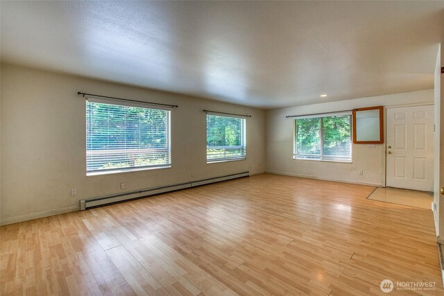 101 Tomihi Dr, Orcas Island, WA 98245 - unfurnished room featuring a baseboard heating unit, light wood finished floors, and baseboards