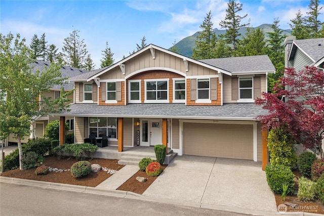 3098 SE 16th St, North Bend, WA 98045 - view of front of house with a porch, a garage, a mountain view, concrete driveway, and a shingled roof