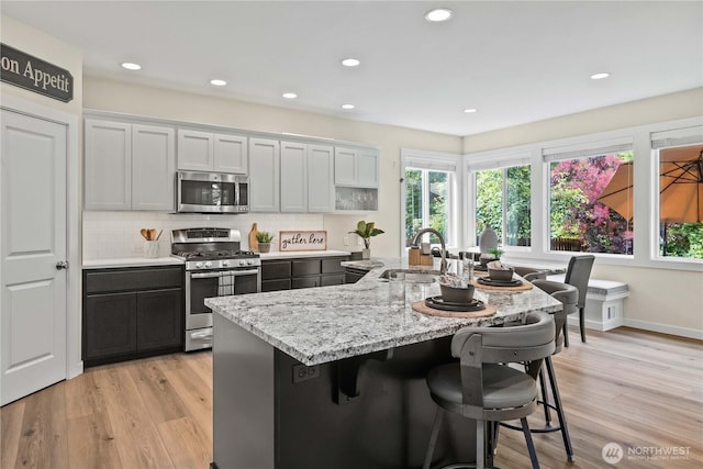 3098 SE 16th St, North Bend, WA 98045 - kitchen featuring appliances with stainless steel finishes, a sink, plenty of natural light, a breakfast bar, and recessed lighting