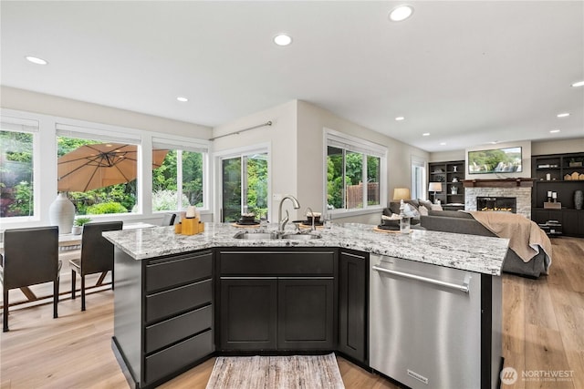 3098 SE 16th St, North Bend, WA 98045 - kitchen with stainless steel dishwasher, a sink, a fireplace, recessed lighting, and light stone counters