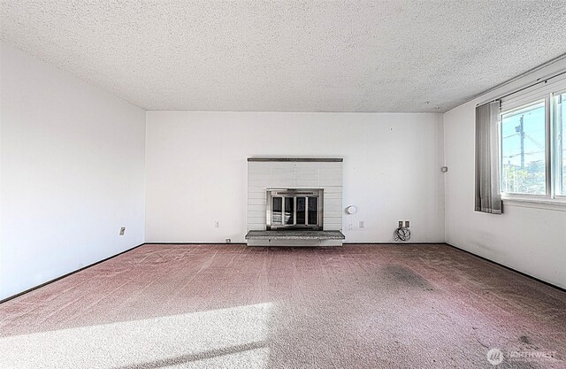 24427 14th Ave S, Des Moines, WA 98198 - unfurnished living room featuring carpet floors, a textured ceiling, and a fireplace