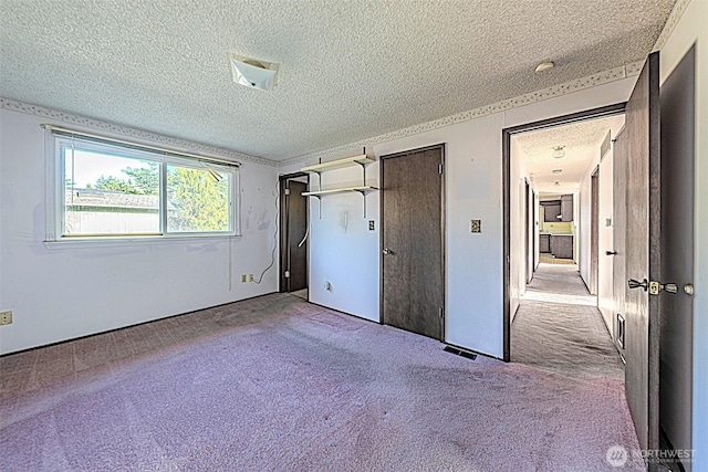 24427 14th Ave S, Des Moines, WA 98198 - unfurnished bedroom with a textured ceiling, carpet, and two closets