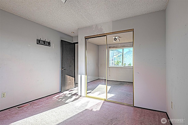 24427 14th Ave S, Des Moines, WA 98198 - unfurnished bedroom featuring carpet flooring, a textured ceiling, and a closet