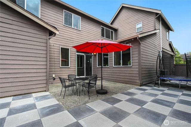 10821 Eastridge Dr NE, Redmond, WA 98053 - back of house with a trampoline, a patio area, and outdoor dining space