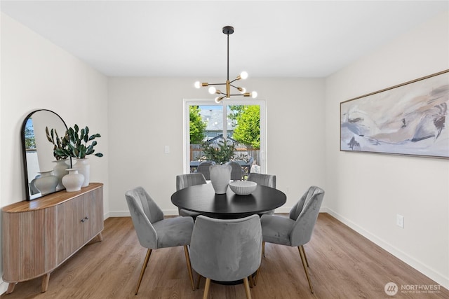 5041 Bowen Pl S, Seattle, WA 98118 - dining room featuring a chandelier, light wood finished floors, and baseboards