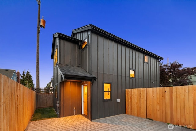 3720 36th Ave SW Unit B, Seattle, WA 98126 - view of front of house featuring board and batten siding, a fenced backyard, and a patio