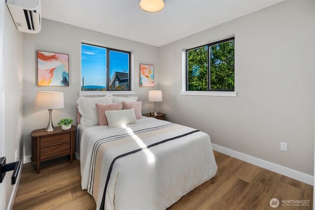 3720 36th Ave SW Unit B, Seattle, WA 98126 - bedroom with an AC wall unit, baseboards, and light wood finished floors