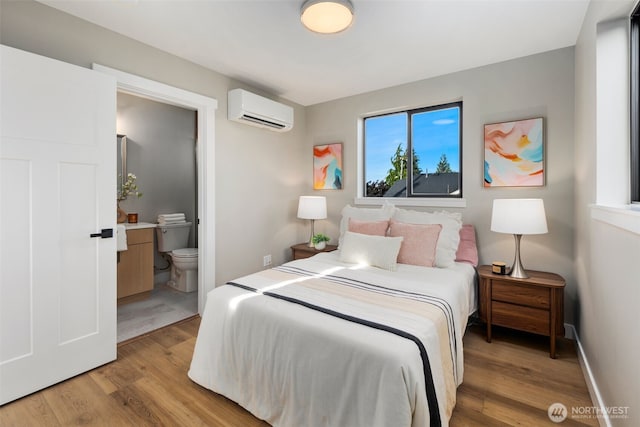 3720 36th Ave SW Unit B, Seattle, WA 98126 - bedroom featuring a wall unit AC, light wood-type flooring, and connected bathroom