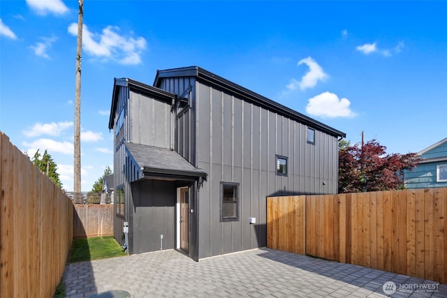 3720 36th Ave SW Unit B, Seattle, WA 98126 - view of property exterior with board and batten siding, a patio area, and a fenced backyard