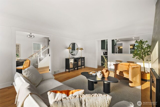3722 36th Ave SW, Seattle, WA 98126 - living room featuring stairs, wood finished floors, a chandelier, and baseboards