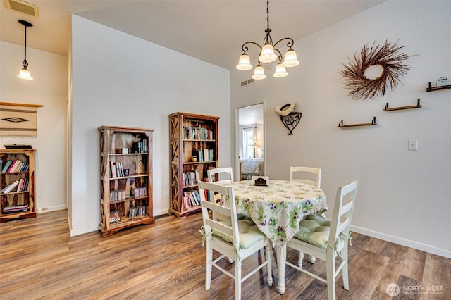 424 Maranatha, Kelso, WA 98626 - dining area featuring wood finished floors, a chandelier, and baseboards