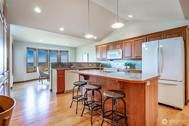 8022 Makah Rd, Blaine, WA 98230 - kitchen featuring white appliances, light countertops, backsplash, light wood-style flooring, and vaulted ceiling