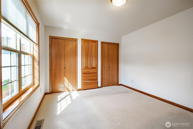 8022 Makah Rd, Blaine, WA 98230 - unfurnished bedroom with light carpet, two closets, and baseboards