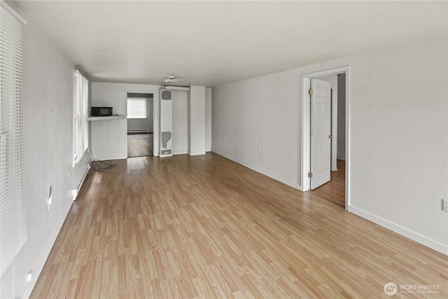 3718 Wetmore Ave, Everett, WA 98201 - unfurnished living room featuring a baseboard radiator, wood finished floors, and baseboards