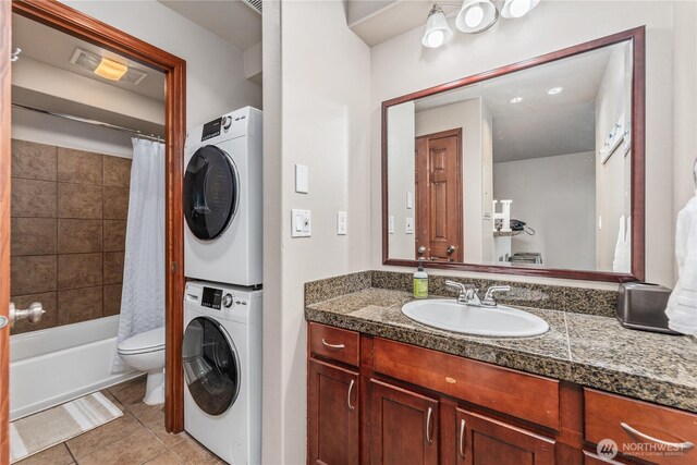 322 W Woodin Ave Unit 620, Chelan, WA 98816 - full bathroom featuring stacked washer / dryer, tile patterned flooring, vanity, toilet, and shower / tub combo