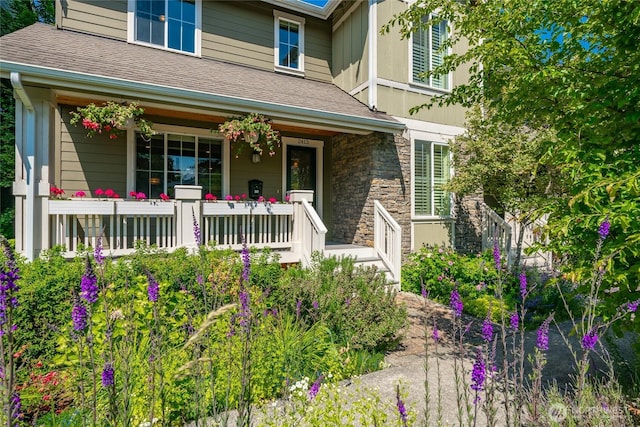 2413 Peabody St, Bellingham, WA 98225 - view of exterior entry with covered porch, stone siding, and roof with shingles
