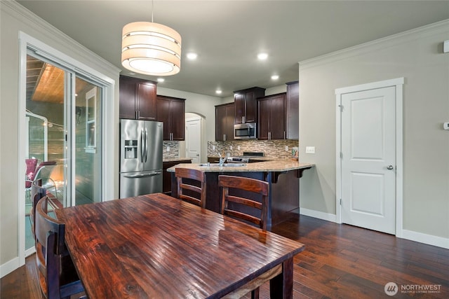 2413 Peabody St, Bellingham, WA 98225 - dining space with dark wood-style flooring, baseboards, arched walkways, ornamental molding, and recessed lighting