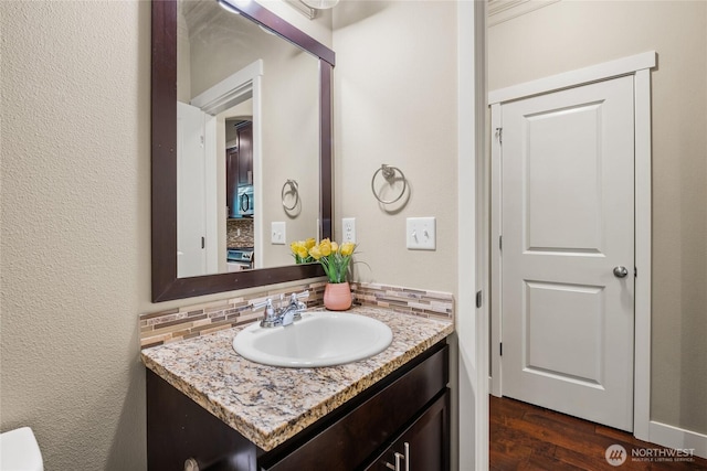 2413 Peabody St, Bellingham, WA 98225 - bathroom with vanity, wood finished floors, and decorative backsplash