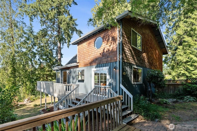 19709 Whiteman Cove Rd SW, Longbranch, WA 98351 - view of front of house with board and batten siding, a deck, and stairway