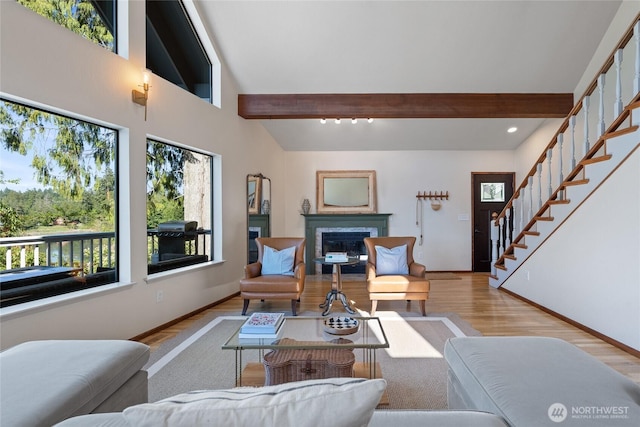 19709 Whiteman Cove Rd SW, Longbranch, WA 98351 - living room with healthy amount of natural light, wood finished floors, beam ceiling, a fireplace, and stairs