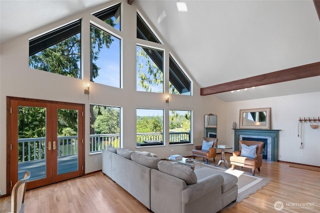 19709 Whiteman Cove Rd SW, Longbranch, WA 98351 - living area featuring a fireplace with flush hearth, french doors, high vaulted ceiling, beam ceiling, and wood finished floors
