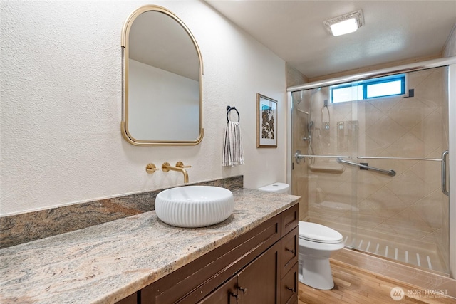 19709 Whiteman Cove Rd SW, Longbranch, WA 98351 - bathroom with vanity, wood finished floors, a shower stall, and a textured wall