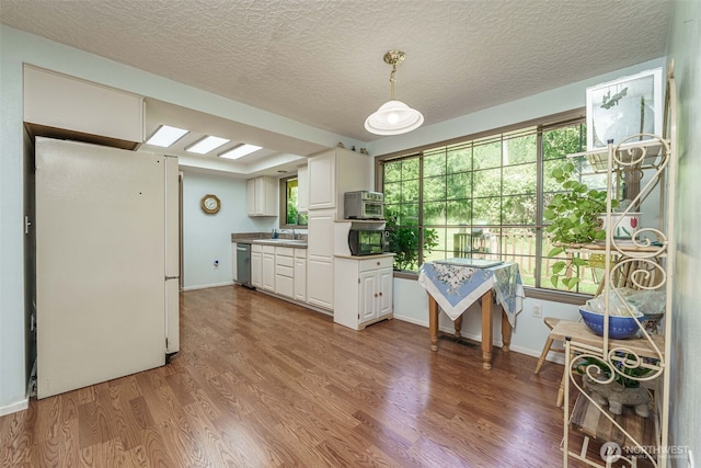 29139 NE Hammond Ct, Battle Ground, WA 98604 - kitchen with dishwasher, wood finished floors, white cabinets, a textured ceiling, and a sink