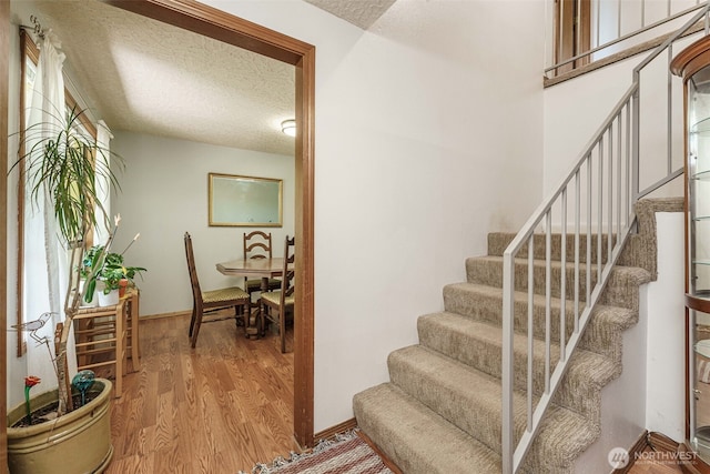 29139 NE Hammond Ct, Battle Ground, WA 98604 - stairs with wood finished floors, a textured ceiling, and baseboards