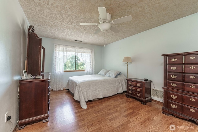 29139 NE Hammond Ct, Battle Ground, WA 98604 - bedroom with light wood-style flooring, a textured ceiling, and ceiling fan