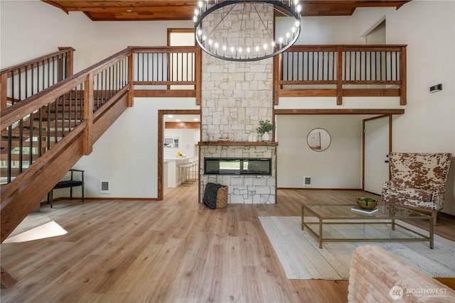 435 Thumper Ln, Camano Island, WA 98282 - unfurnished living room featuring a chandelier, wood finished floors, stairs, wooden ceiling, and a high ceiling