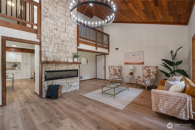 435 Thumper Ln, Camano Island, WA 98282 - living room with a towering ceiling, a stone fireplace, a chandelier, wood finished floors, and wood ceiling
