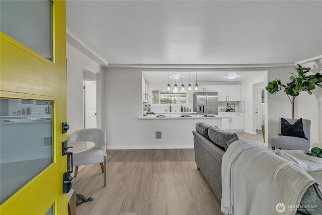 10209 65th Ave S, Seattle, WA 98178 - living room with light wood-style floors, a chandelier, and baseboards