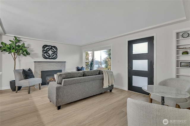 10209 65th Ave S, Seattle, WA 98178 - living area featuring a warm lit fireplace, light wood-style floors, baseboards, and built in features