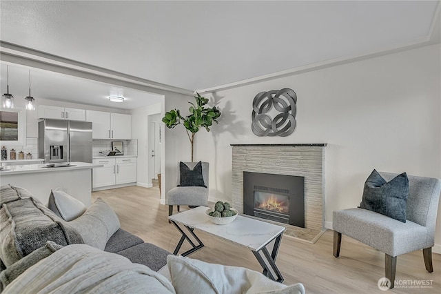 10209 65th Ave S, Seattle, WA 98178 - living room featuring light wood-type flooring, a glass covered fireplace, and baseboards